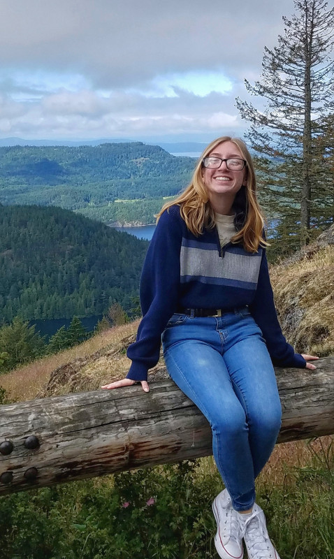 picture of my sitting on a rock wall smiling