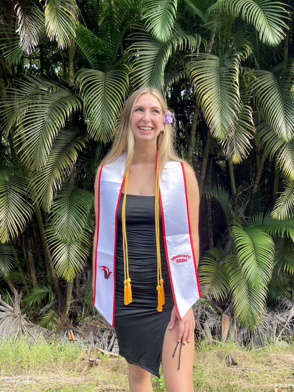 primary photo of Ashton Jessee wearing a black dress with her honors cords and student athlete stole