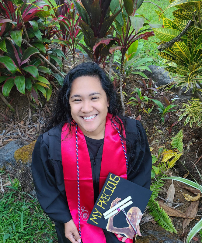 I sit on a mossy rock surrounded by ti plants, proudly and finally wearing the boxy graduation gown that somehow manages to make my 4 foot 10 frame look even shorter. In addition to the gown are the red stole of the Phi Alpha Theta honor society, and the red, white, and blue veteran cord. In my hand, the graduation cap with the white tassel of history and the maroon of linguistics. Gollum triumphantly holds up two diplomas, and in gold glitter are the words "My Precious"