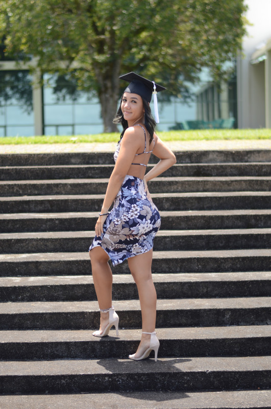 Kylie smiling with her cap while standing on steps.