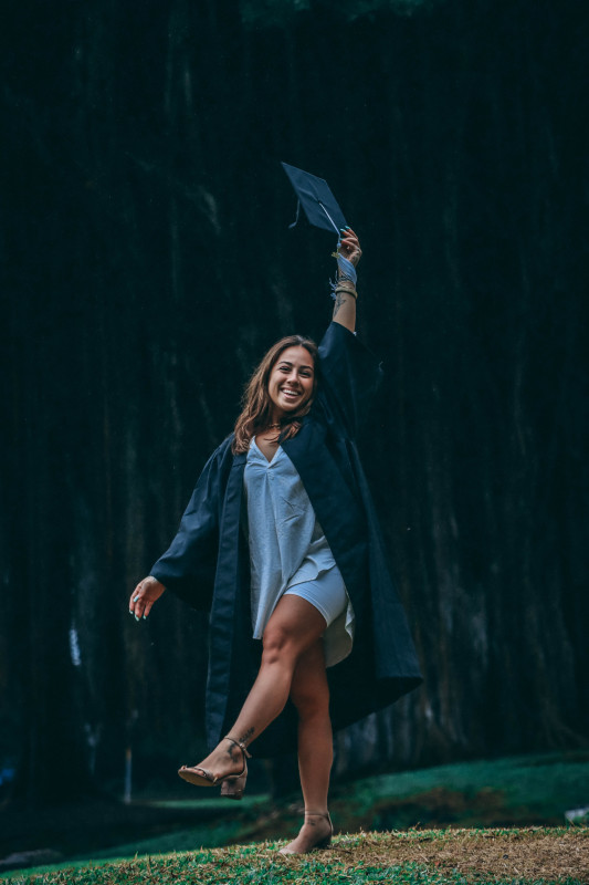 Kaitlyn holding her cap up high in celebration.