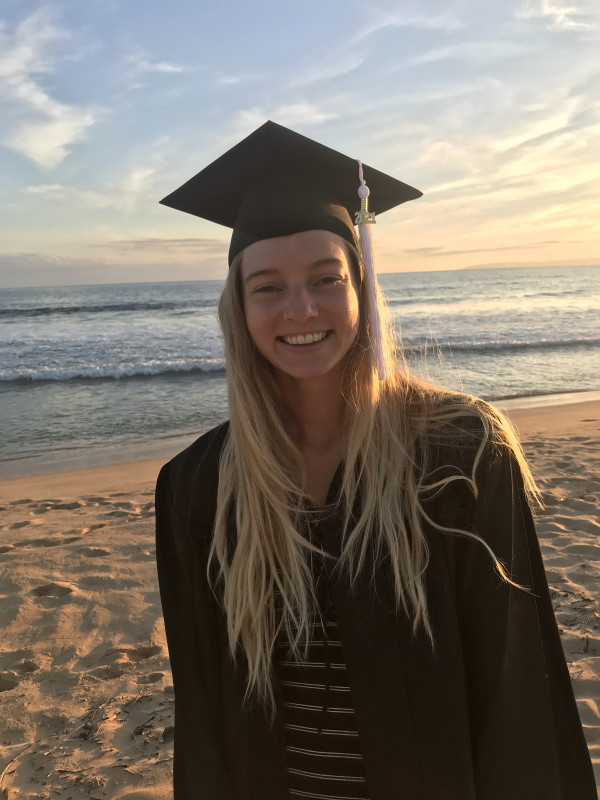 Smiling in graduation regalia