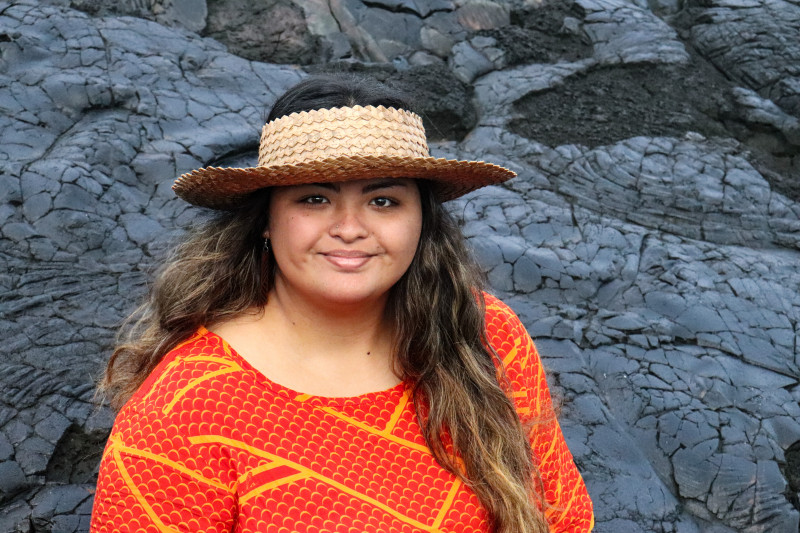 A self-portrait of myself in a red dress and faux lauhala hat