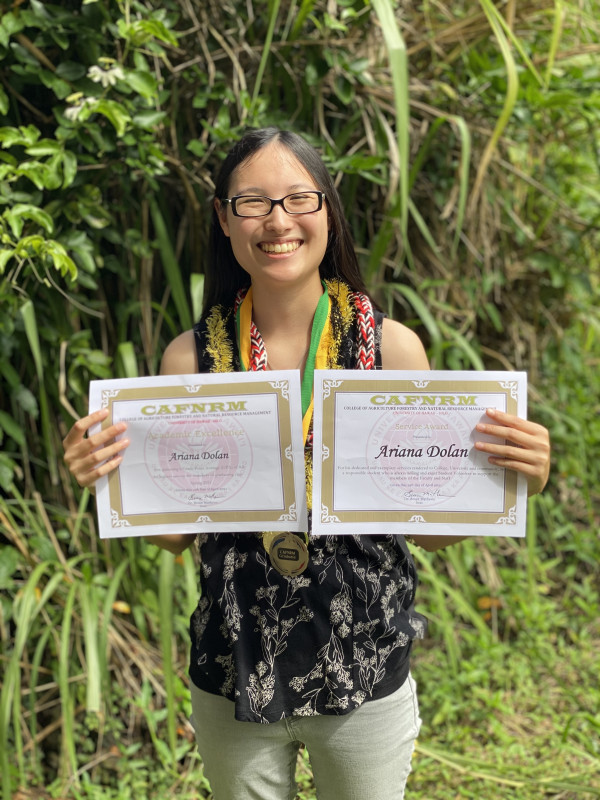 Ariana holding two CAFNRM certificates and wearing three CAFNRM medals.