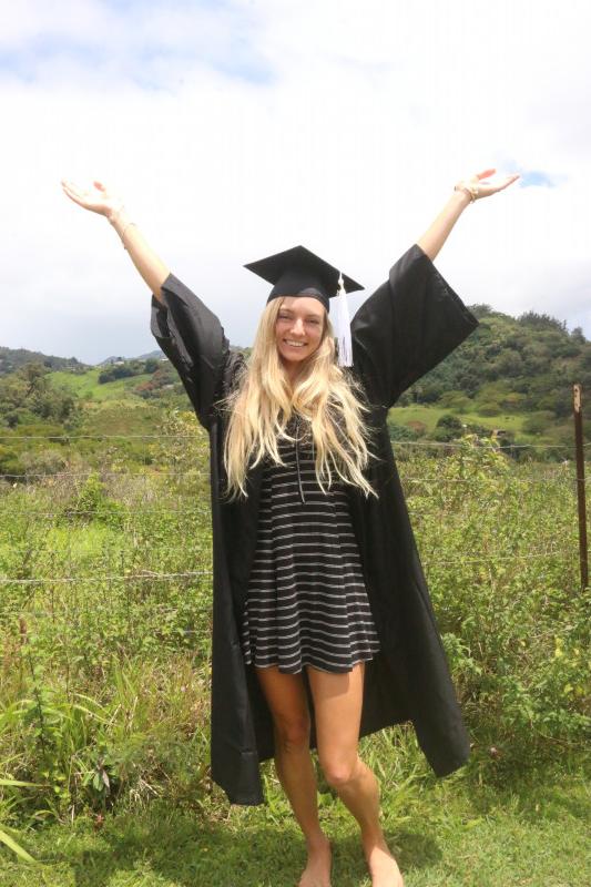 Smiling in graduation regalia