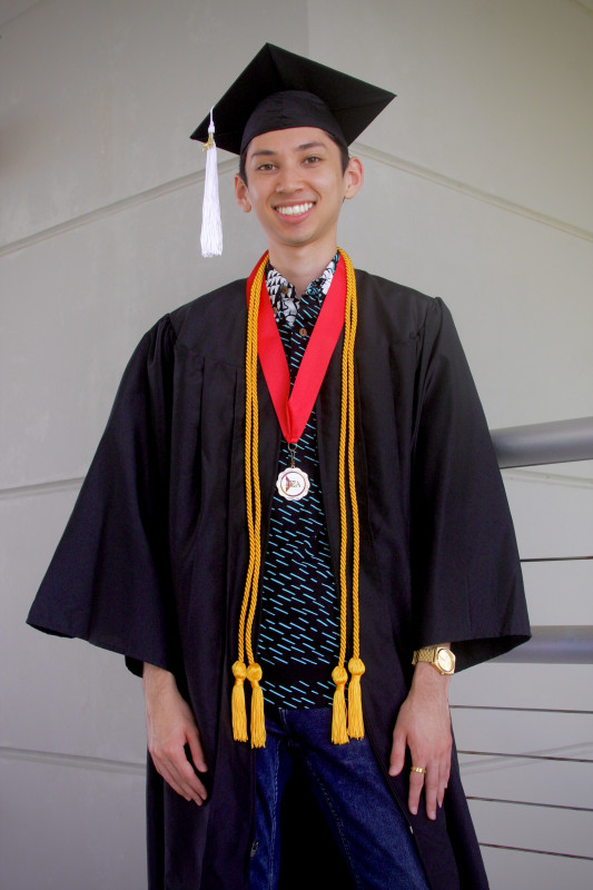 Graduate James Matsumoto wearing graduate regalia.