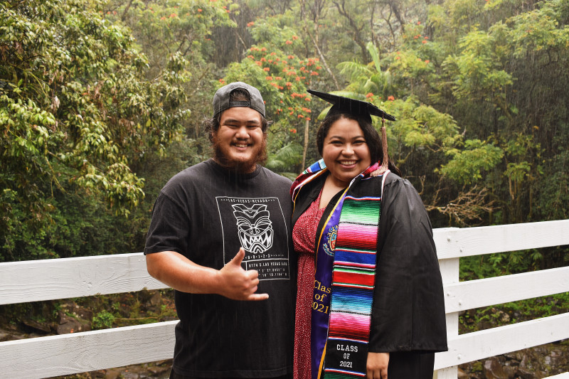 Couple in front of greenery with rain falling down