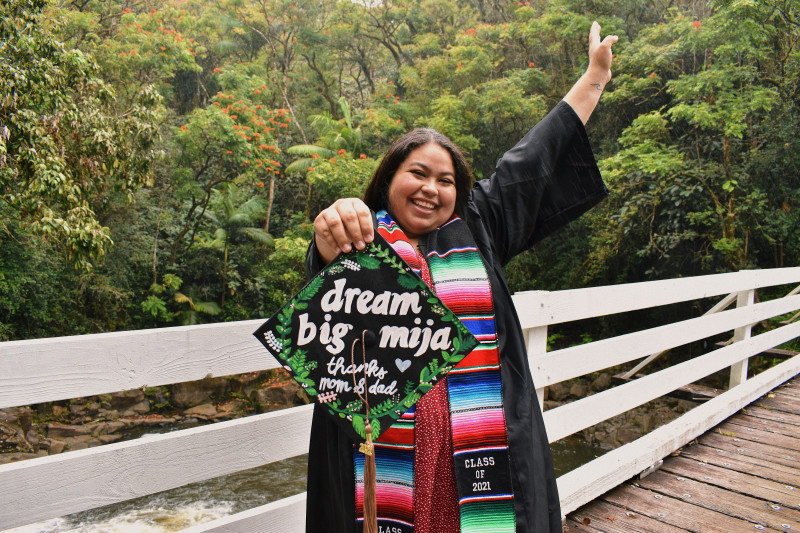 Graduate holding decorated graduation cap