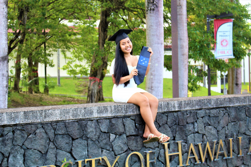 Standing in front of the University of Hawaii at Hilo entrance sign using my cap and FSM flag sash.