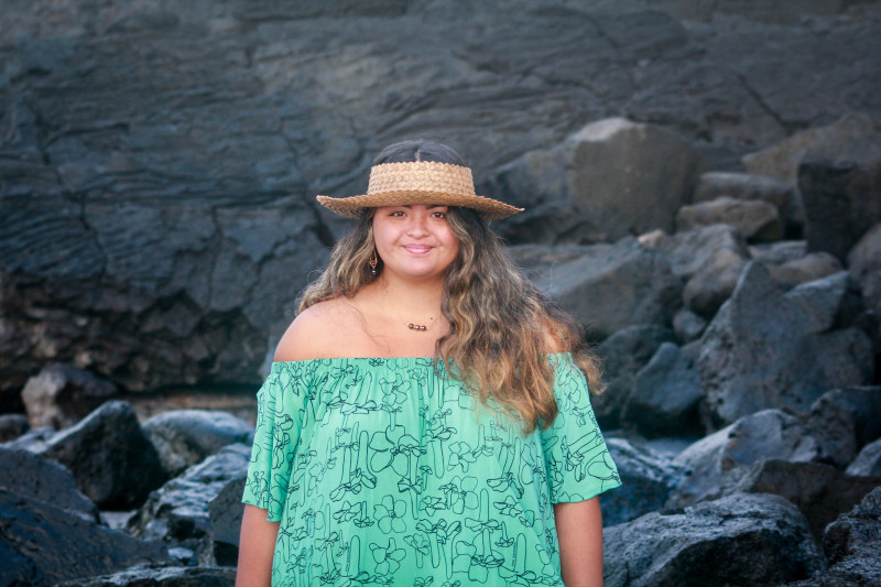 A self portrait of myself in a blue off the shoulder dress and in a field of lava rocks