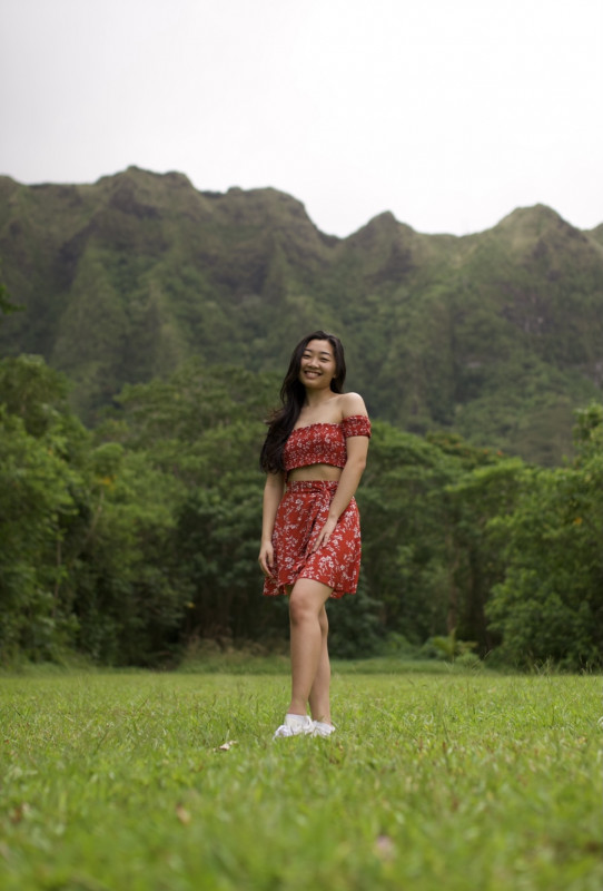 I am standing in a grassy area with a mountain in the background.