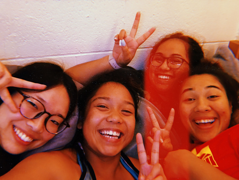 4 Roommates smiling in a photo with peace signs.