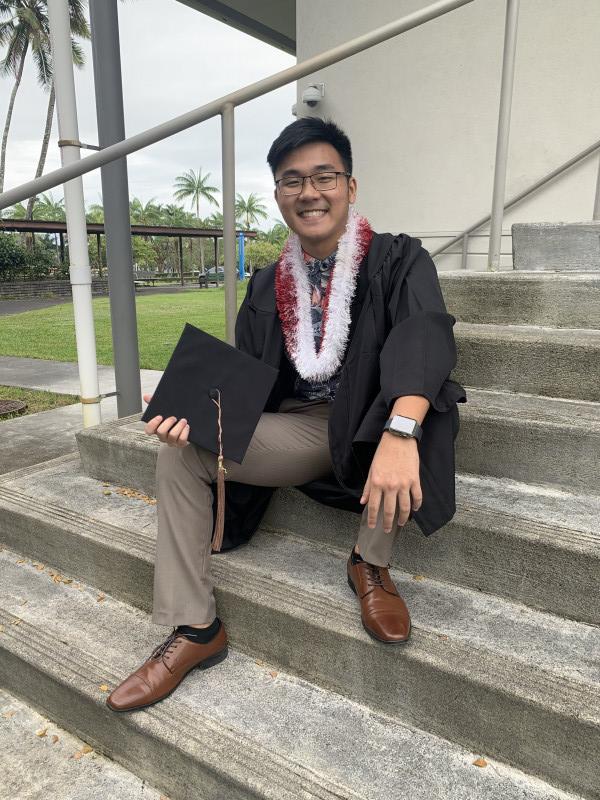 Me sitting stairs with cap and gown