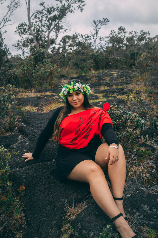 Young wahine sitting on a bed of pahoehoe in an surrounded by ʻōhiʻa!