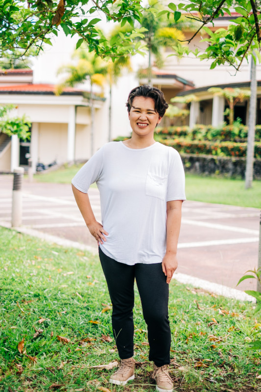 I'm posing and smiling for a photo on campus. I'm also enjoying the sunny day.