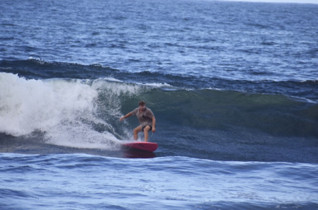 Devin surfing a wave in Hilo