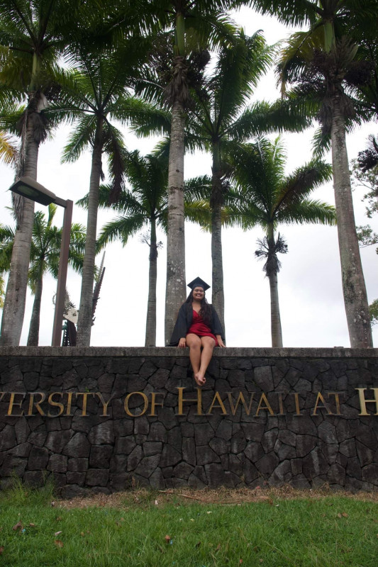 Photo of graduate by the University of Hawaii at Hilo Sign