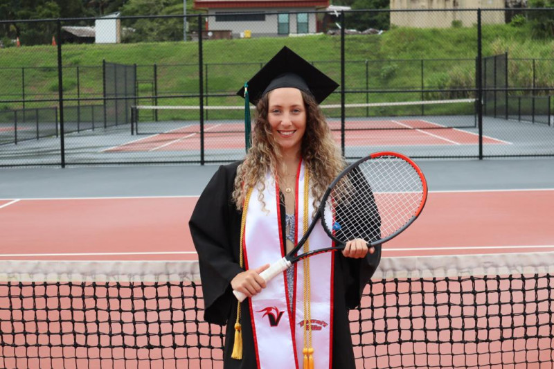In cap and gown with racquet on our home courts
