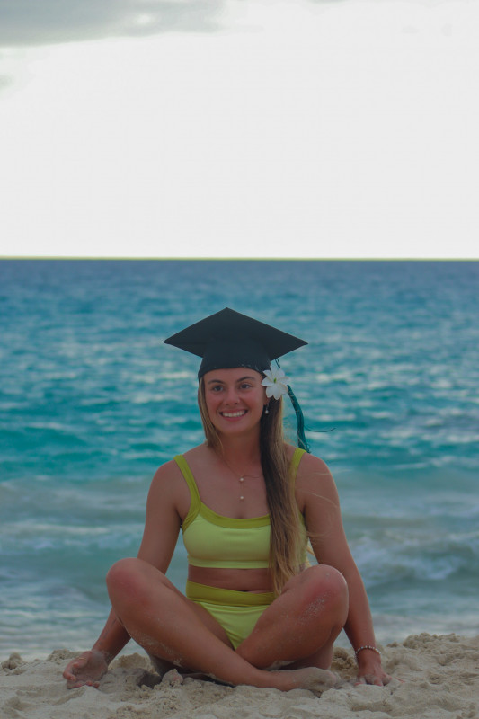 A grad photo of me on the beach in my graduation cap.