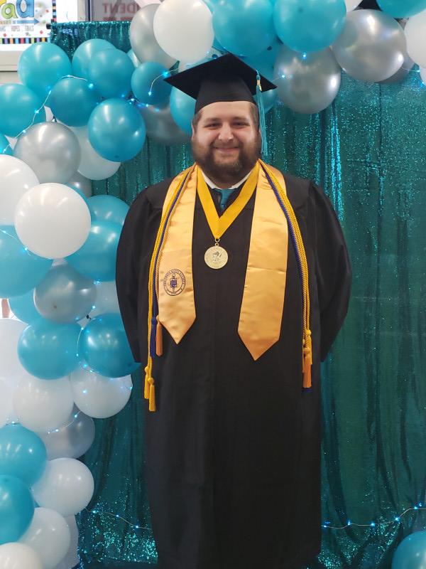 Man in graduation regalia smiling