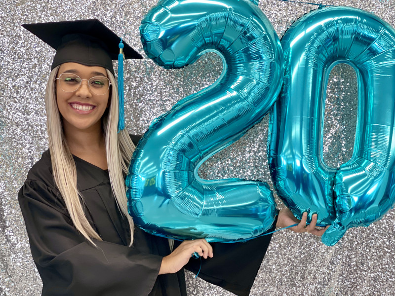 Nicole holding up the number twenty balloon