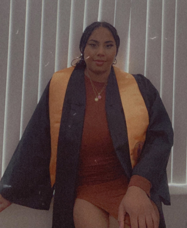 Full-length picture of me in my graduation gown and honor stole.