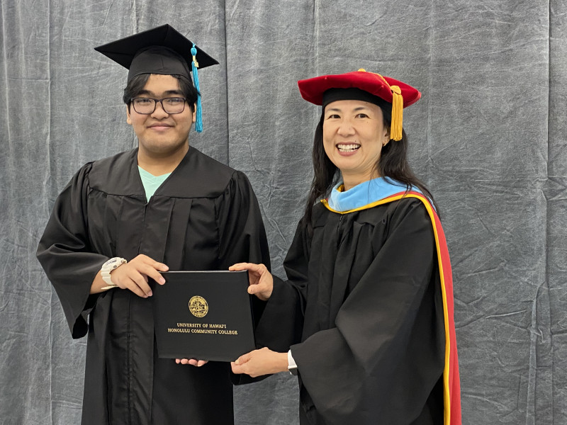 Me holding diploma with Chancellor Lee