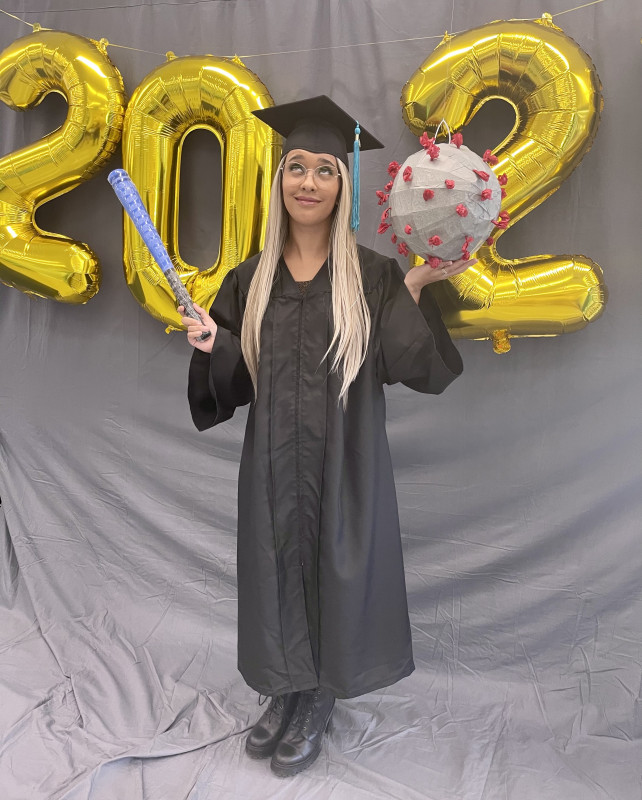 Nicole holing a baseball bat and a coronavirus model in her hands