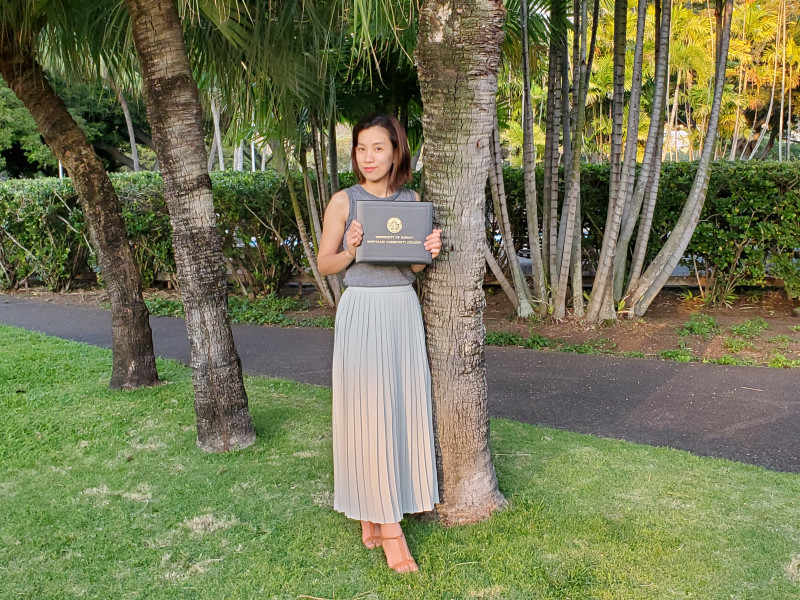 Beneath the palm tree there I am with the diploma.