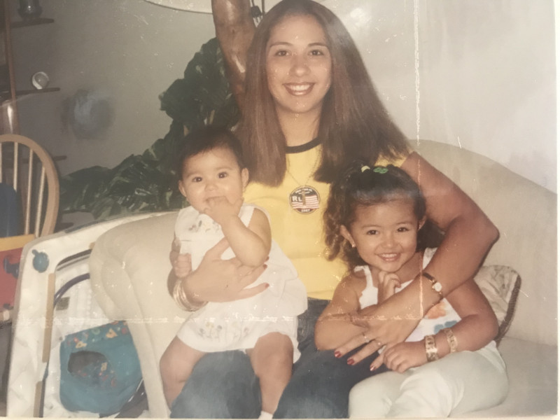 My mom (middle), little sister (in moms arms) and I smiling