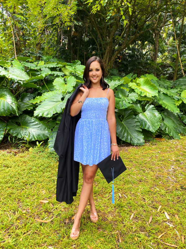 Baby blue dress looking forward holding cap and gown