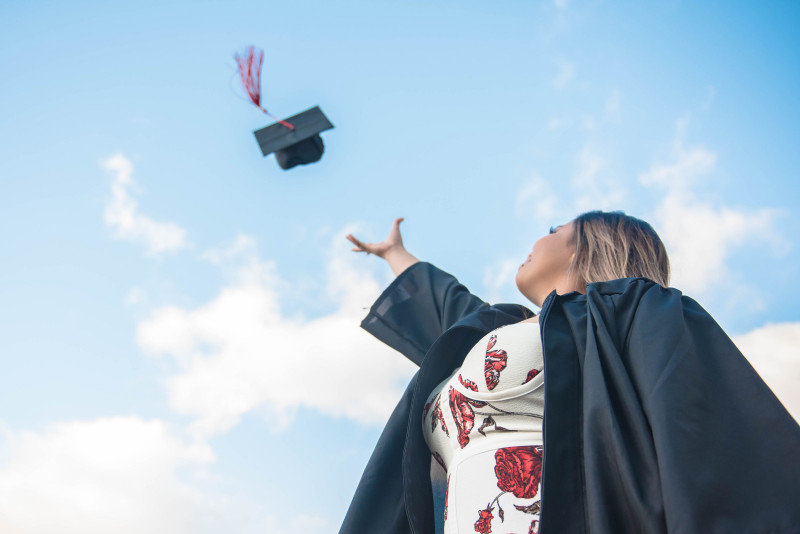 Graduate throwing cap in the sky.