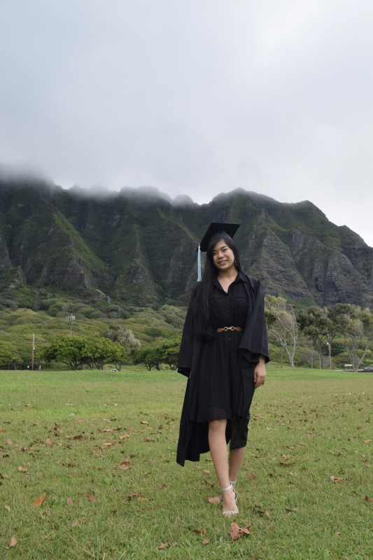 Me standing in the field at Kualoa Regional Park with my cap and gown