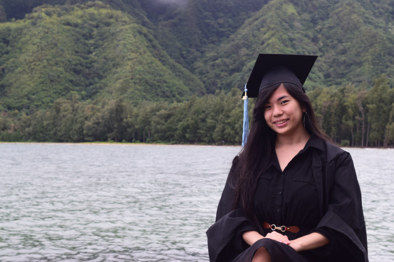 Me wearing my cap and gown while smiling and facing the camera. This picture was taken on the Windward side of Oahu