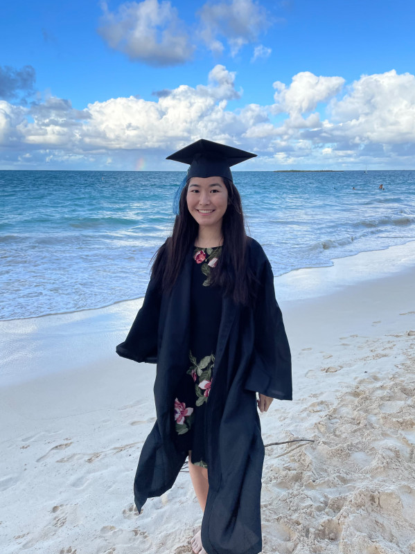 Misa at the beach wearing a cap and gown.