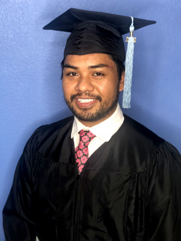 Portrait of Shawn Bucsit in a cap and gown
