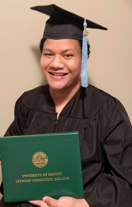 Picture of myself wearing cap and gown with my diploma.