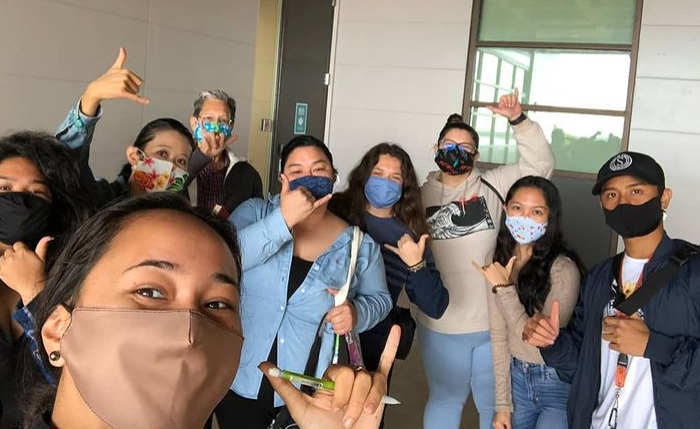Anna shakas with her HAW 101 class.  They're all wearing masks but if they weren't, you'd know they were smiling.