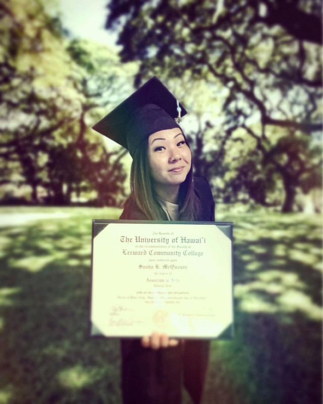 cap and gown up close up photo with diploma taken in shady outdoor area