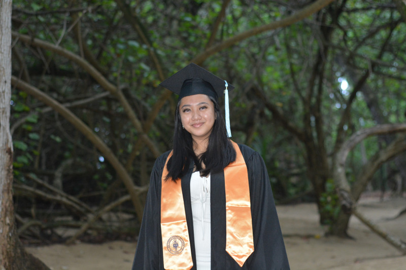 Graduate wearing cap and gown with PTK stole