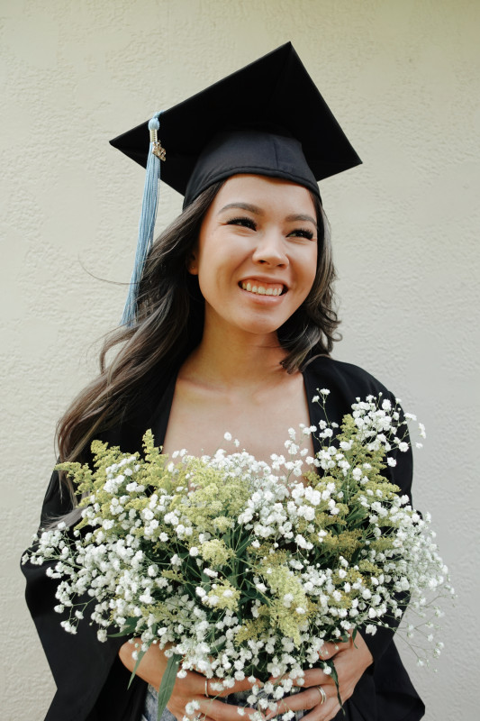 I'm in my cap and gown holding flowers, smiling away from the camera.