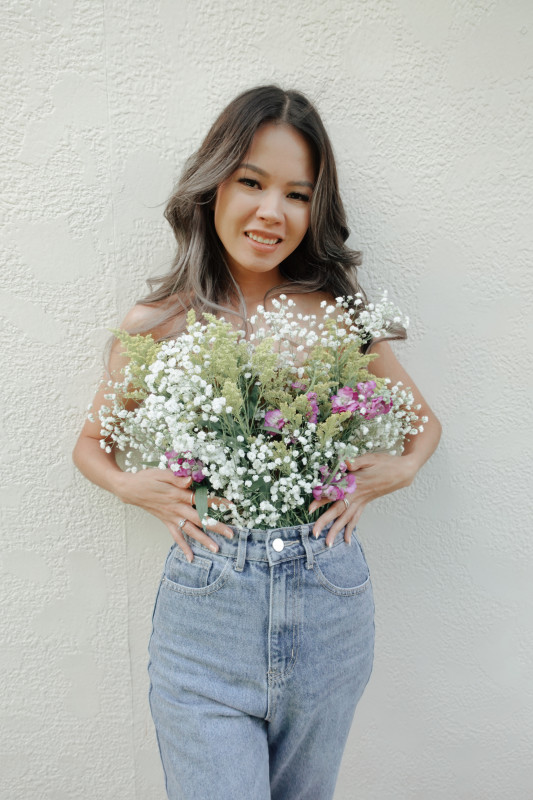 Smiling at the camera with flowers.