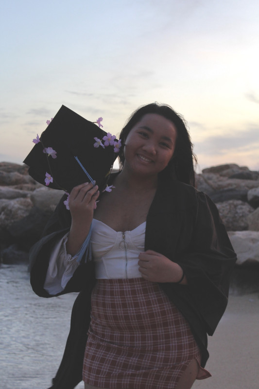 Abegaile wearing her gown while holding her cap and 2023 tassel