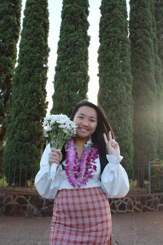 Self-portrait with gifted leis and a bouquet of flowers