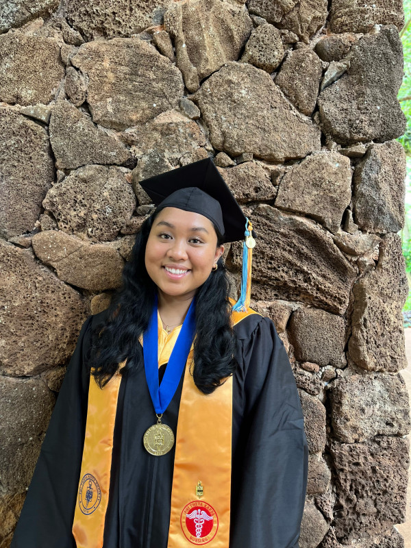 Cap and gown photo with a stone wall background