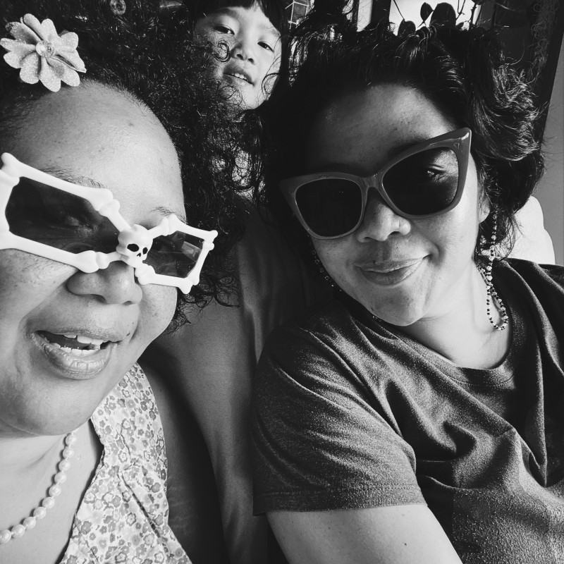 Black and white photograph with 2 females and 1 female child in the background