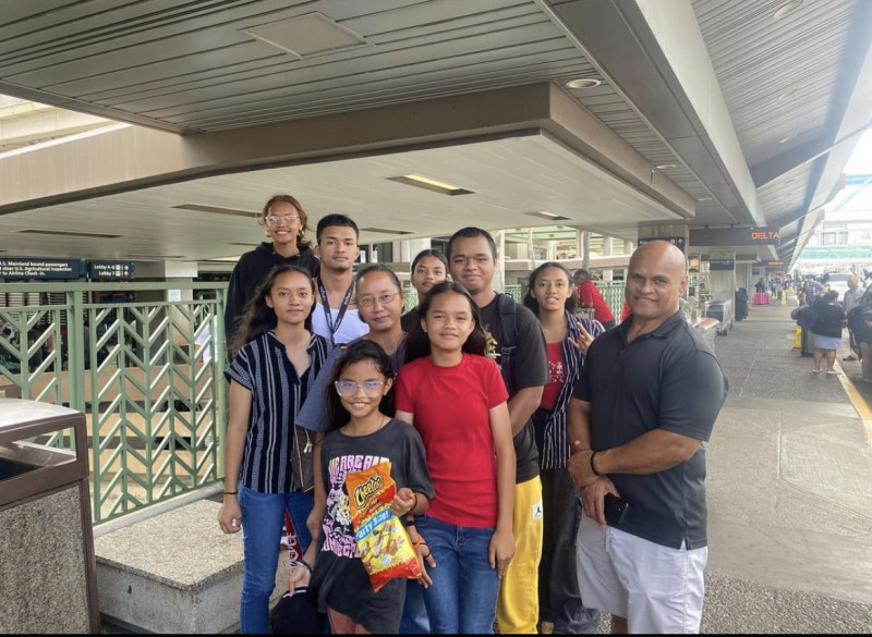 This is a picture of my family at the airport it includes my two brothers, five sisters, and my parents.