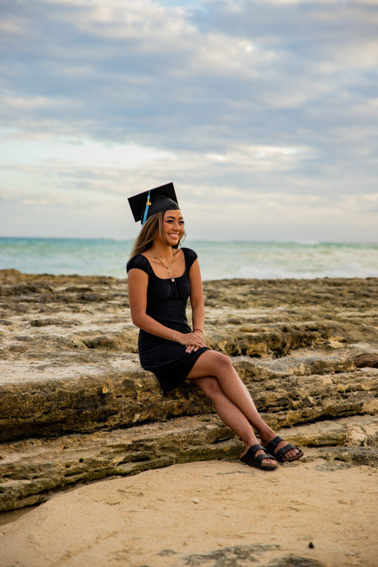 Amanda sitting down cap and gown