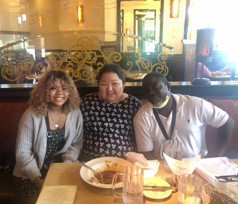 Me on the left with my mom in the middle and my dad on the right sitting at table