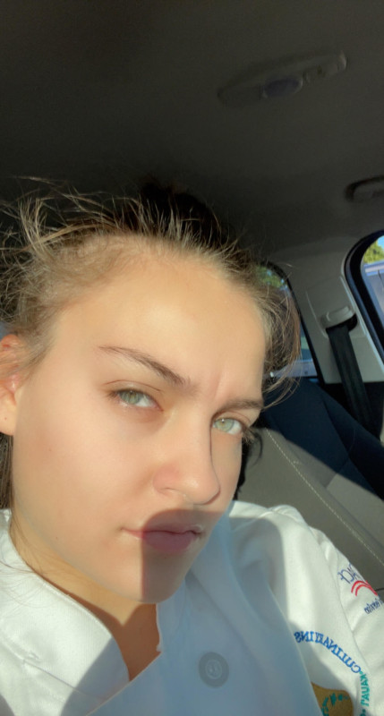 I'm sitting in my car, wearing my culinary uniform
